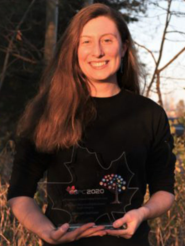 A picture of a white woman holding a trophy