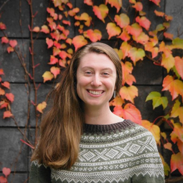 Hannah Harrisson Une photo d'une femme blanche souriante avec un fond de lierre à l'automne.