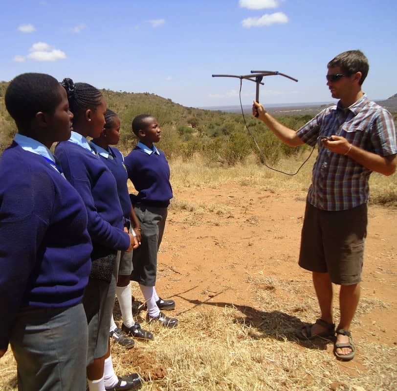 Adam_Ford photo of a white man holding an antenae in a demonstration to four black children