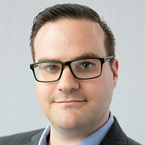 headshot of Lachlan MacKinnon with glasses