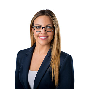 a headshot of Stefanie Colombo with glasses in a suit