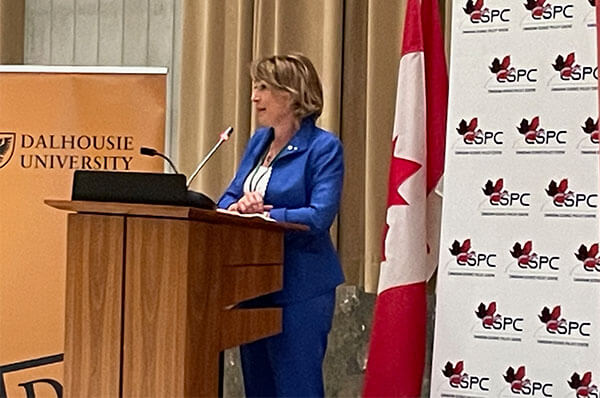 Woman in blue speaking from a podium at the CSPC 2021 The Science Meets Parliament gathering