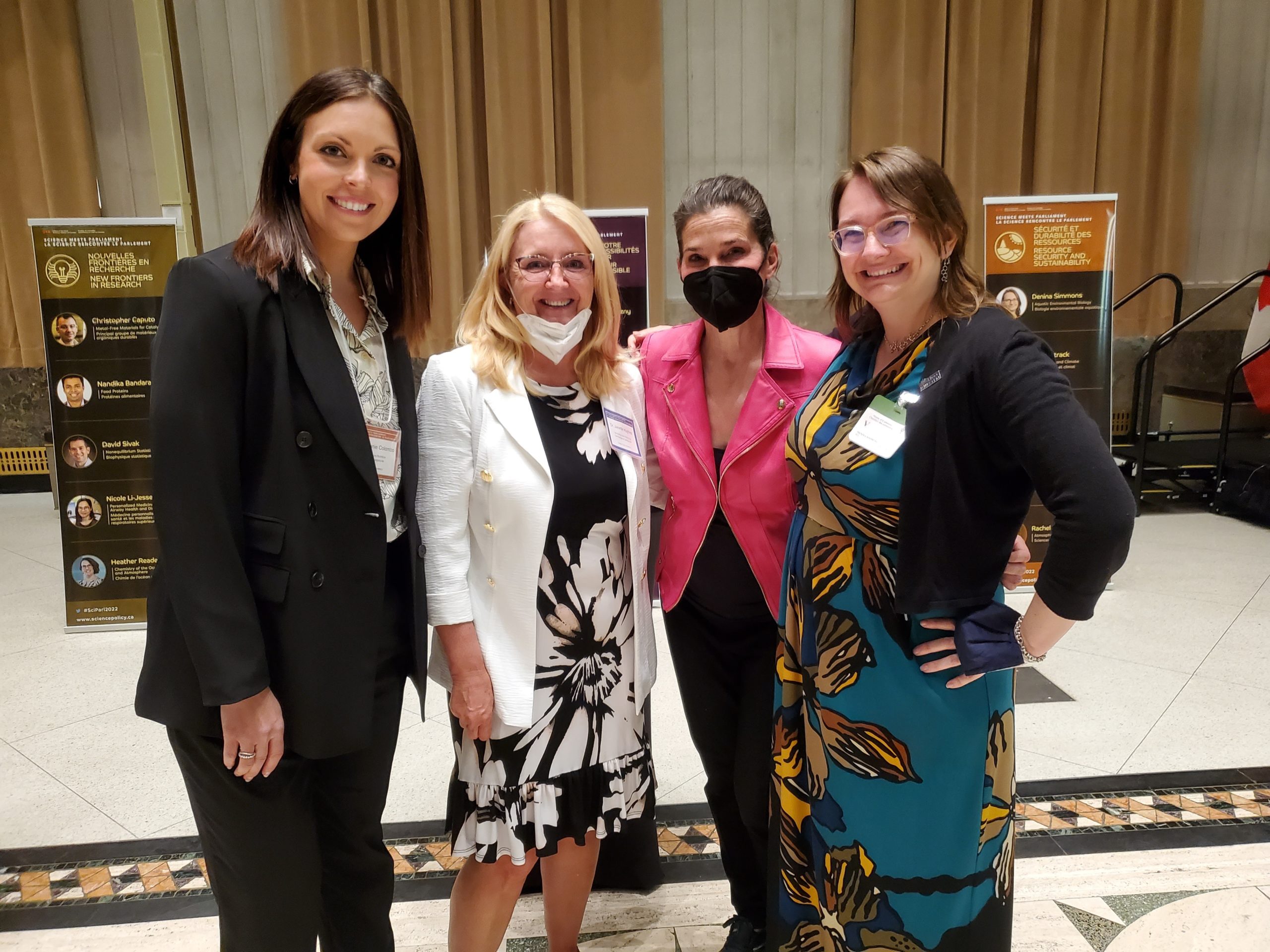 a photo of four women standing together in a lobby