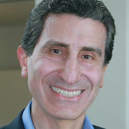 Headshot of a smiling white man with grey hair